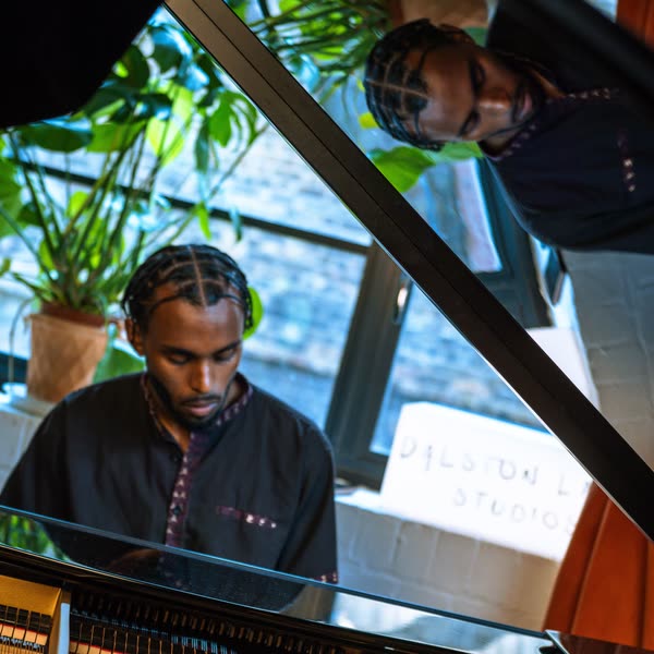 Judah at a grand piano, reflected in its lid